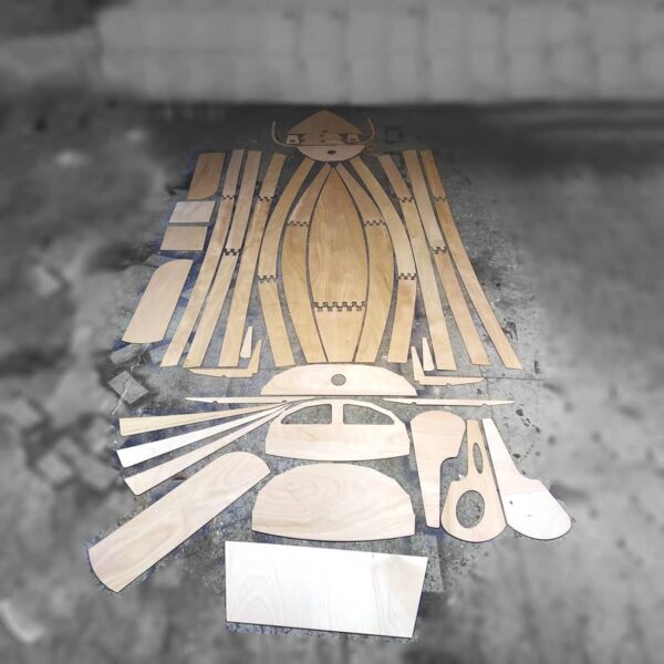 Ensemble des pièces en bois découpées prêtes à l'assemblage pour un bateau en kit.