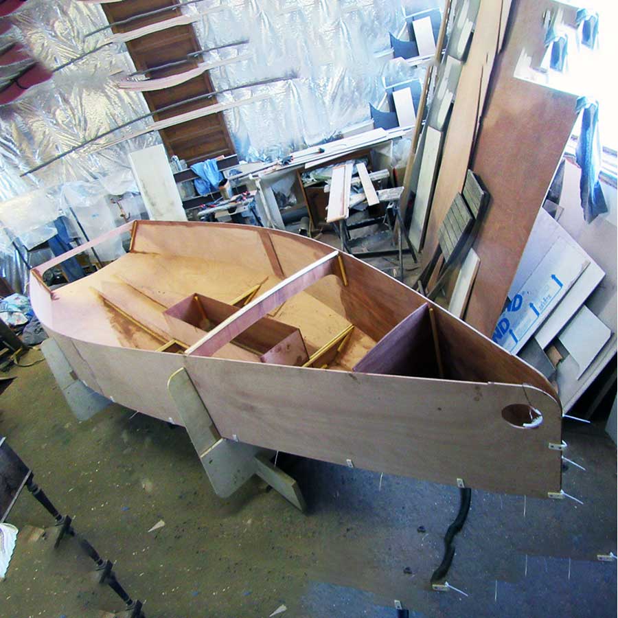 Construction d’un bateau en contreplaqué marine dans un atelier.