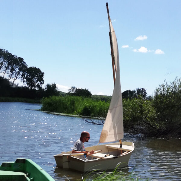Petit voilier Sardinette en navigation sur un plan d’eau, par temps ensoleillé.